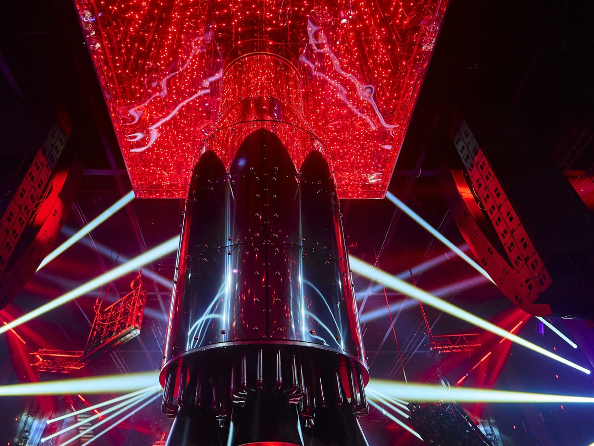 Jet-engine stage sculpture glowing red over the DJ booth